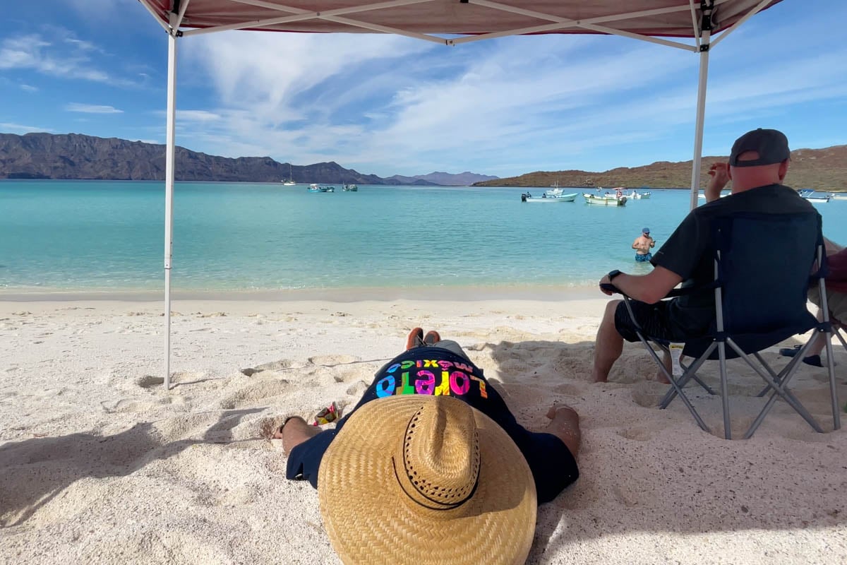 customer-sleeping-on-white-sand-beach-in-baja-mexico